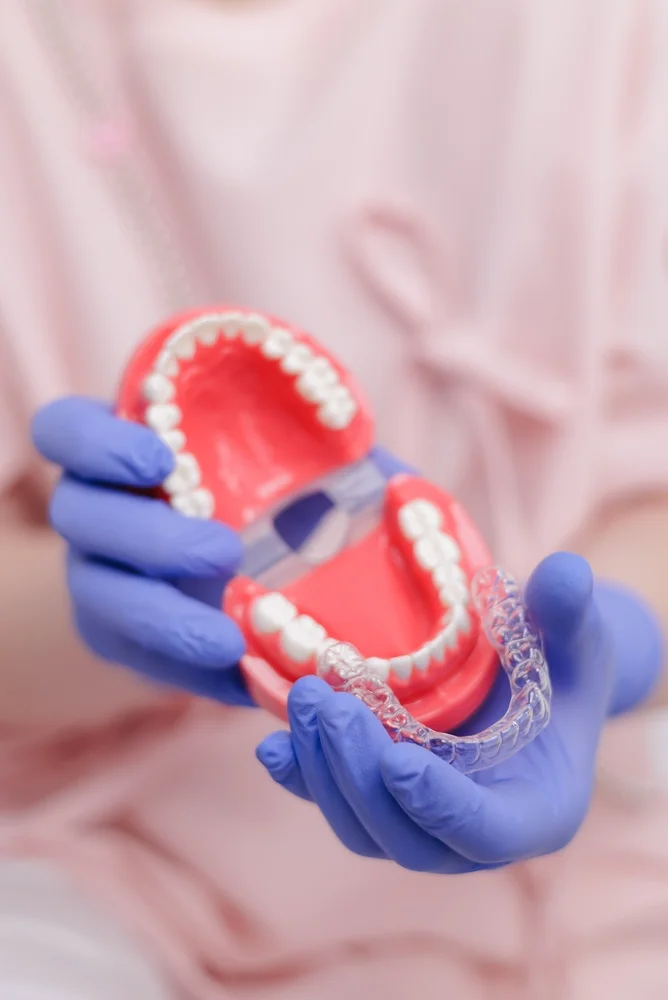 Clear Aligners (3) Gloved hands demonstrating a clear aligner tray fitted to a jaw model at Parramatta Green Dental.