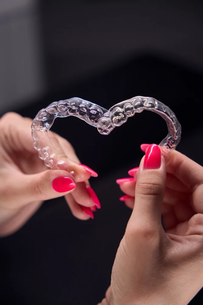 Clear Aligners (4) Hands holding a transparent orthodontic clear aligner tray available at Parramatta Green Dental.